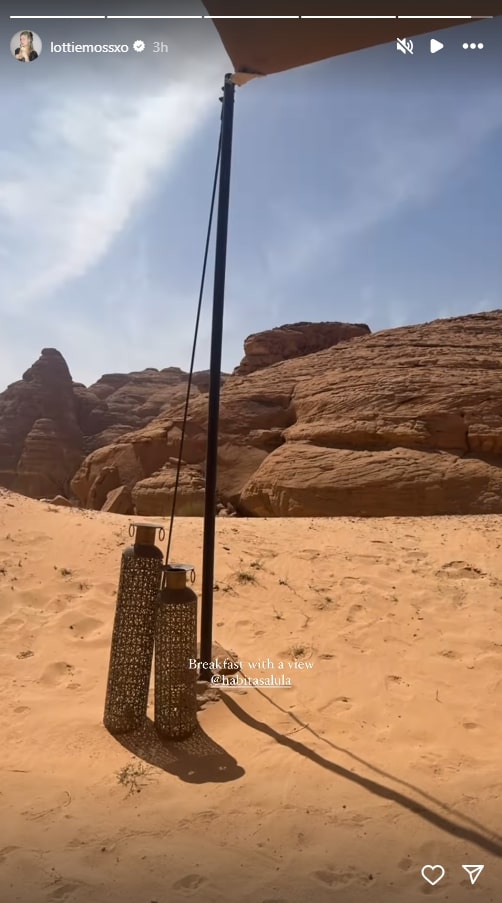 Desert breakfast setting with lanterns and rock formations in the background.