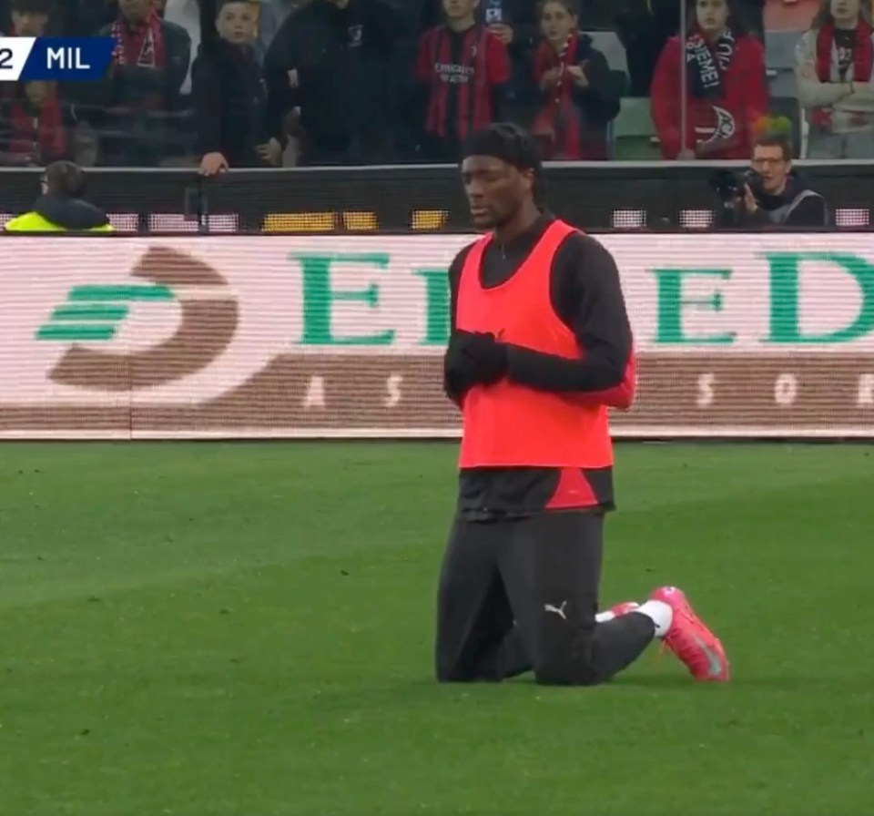 A soccer player kneeling on the field.