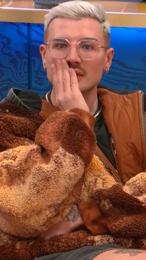 Man in glasses covering his mouth with his hand.