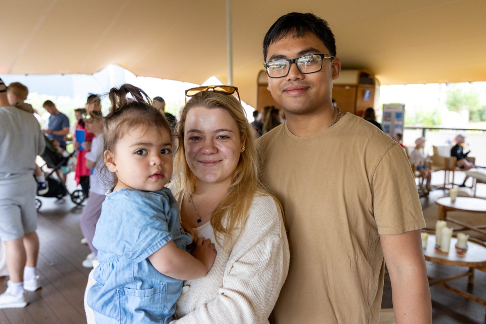 Family portrait: a young couple holding their toddler daughter.