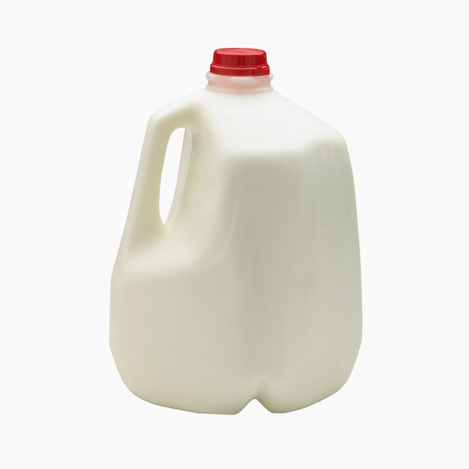 Gallon jug of milk with a red cap.