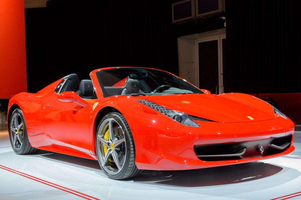Red Ferrari 458 Spider convertible on display.