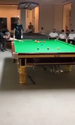 Snooker player taking a shot.