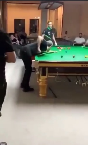 Screenshot of a snooker player bending over a snooker table.