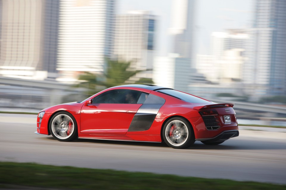 Red Audi R8 sports car driving on a road.