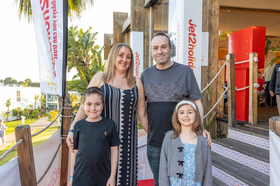 Family portrait in front of Jet2holidays signage.