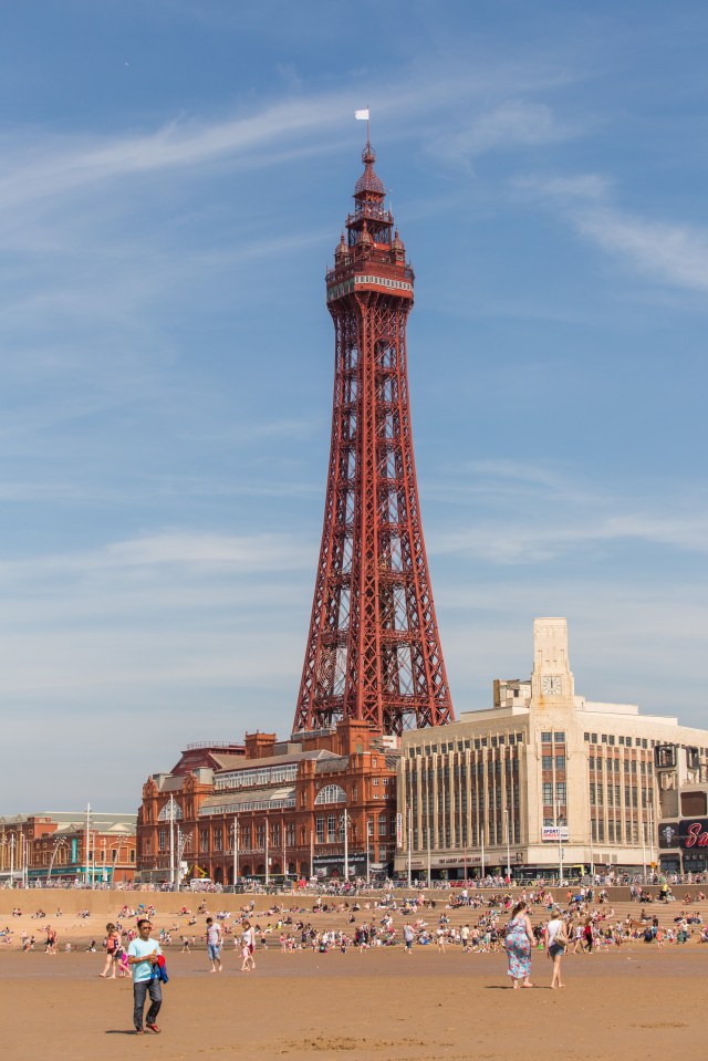 Blackpool Tower and beach with many people.