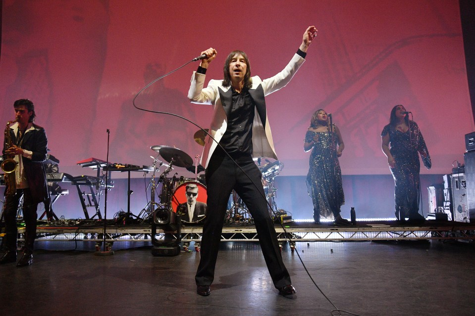 Bobby Gillespie of Primal Scream performing on stage.