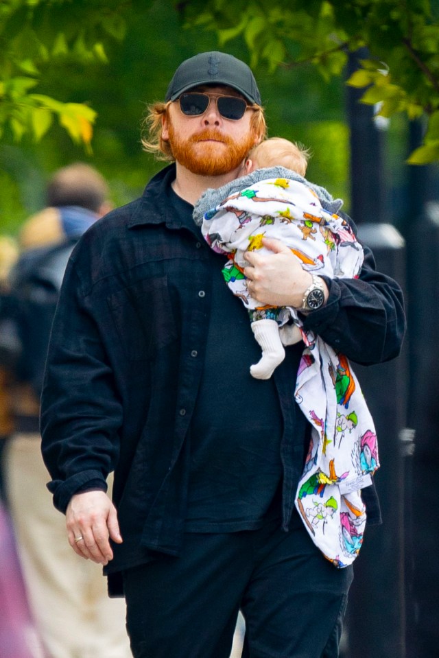 Rupert Grint carrying his newborn baby.