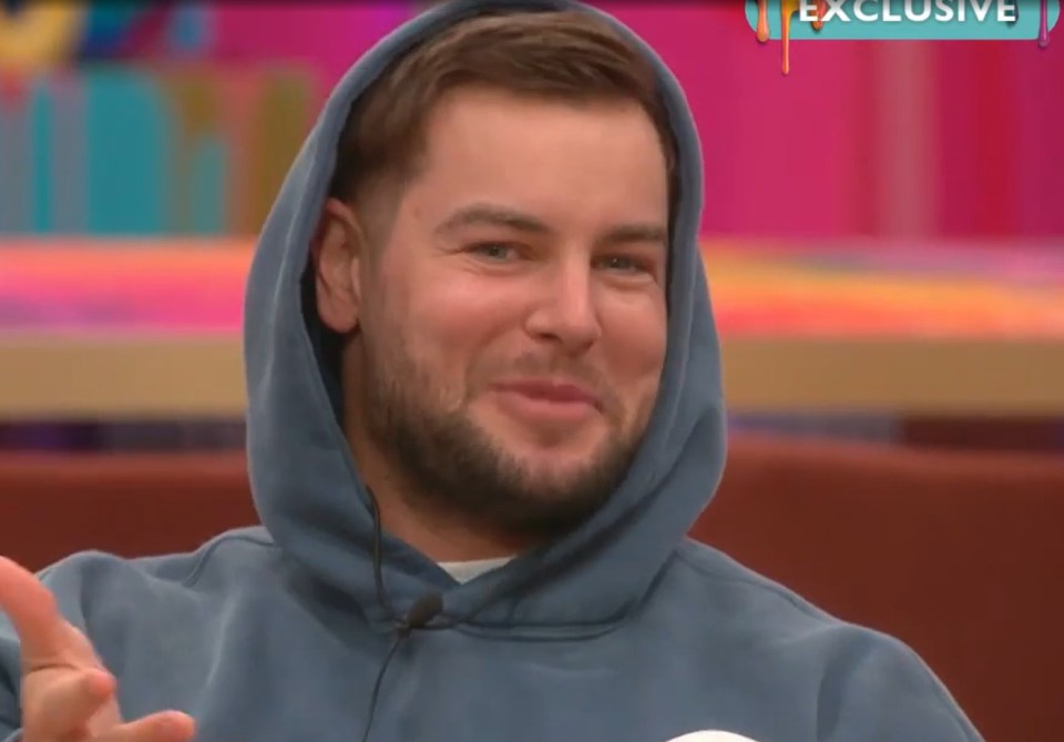 Man in a blue hoodie smiling.