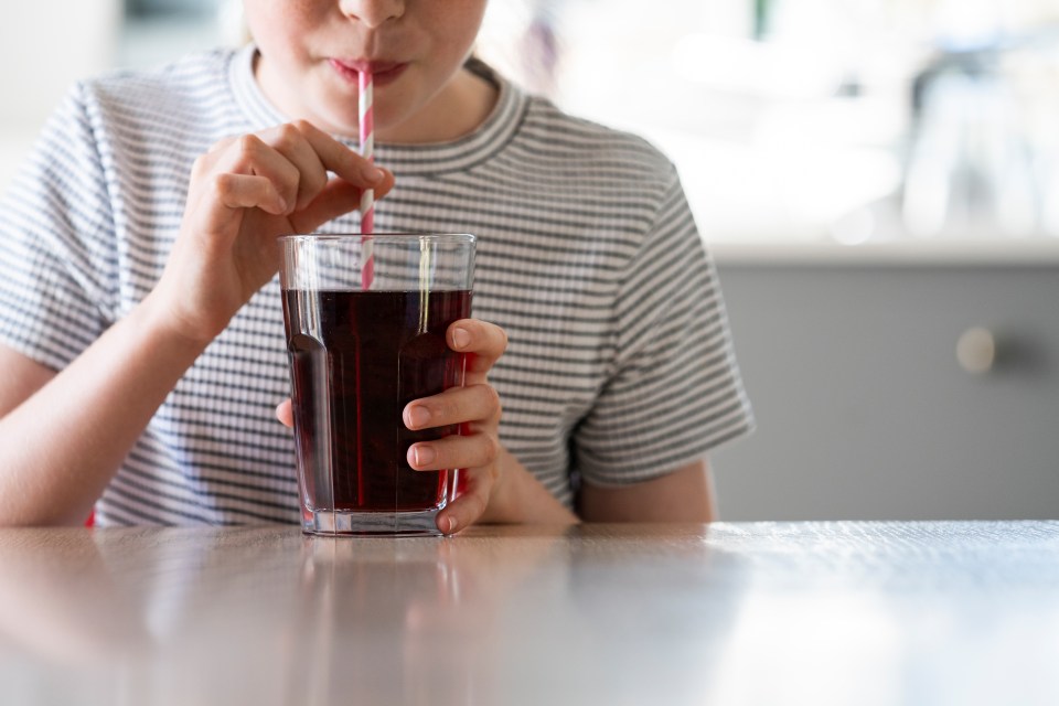 Girl drinking soda through a straw.