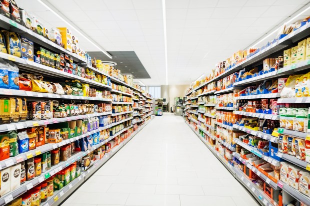 Aisle in a supermarket stocked with various food and drink items.