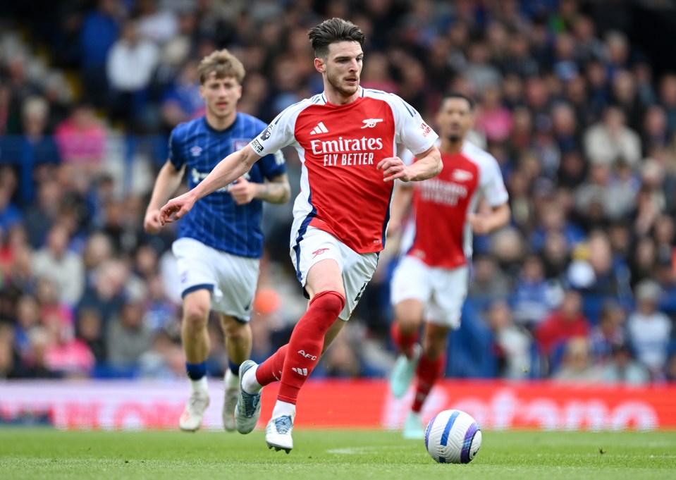 Declan Rice of Arsenal running with the ball during a soccer match.