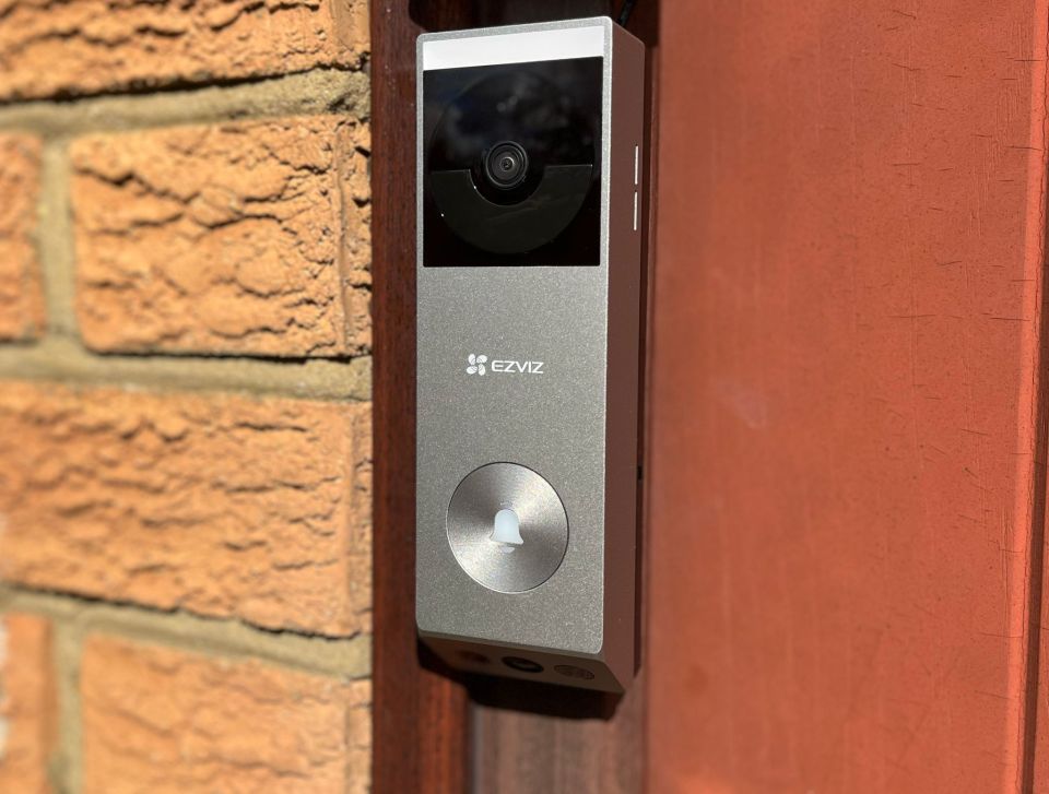 EZVIZ video doorbell mounted on a brick wall.