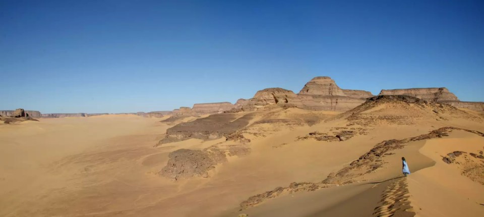 Person walking on sand dune in the Green Sahara.
