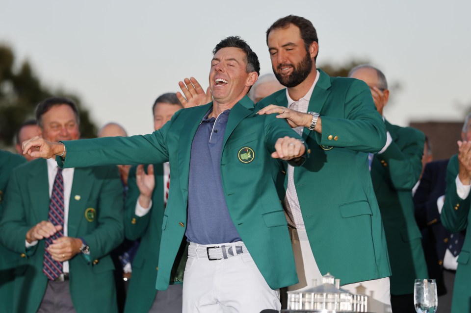 Scottie Scheffler helps Rory McIlroy into his Masters champion's jacket.
