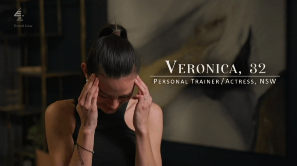 Veronica, 32, personal trainer/actress from NSW, holding her head.