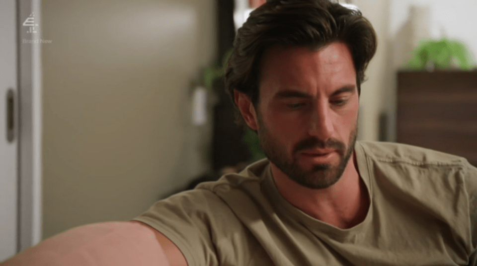 Man looking down, appearing pensive.