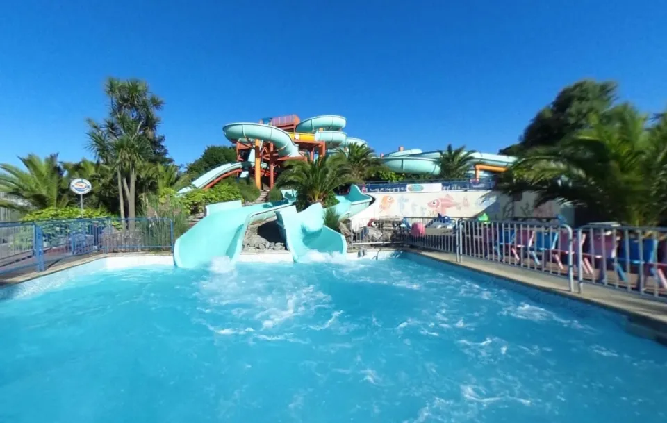 Water park with multiple slides emptying into a pool.