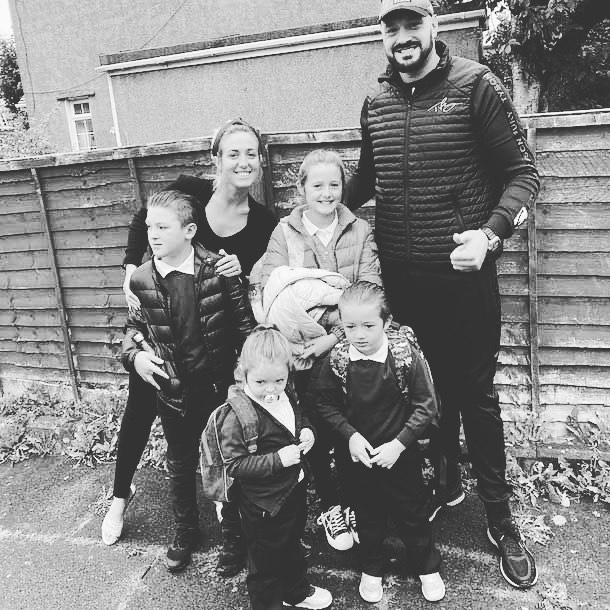 Black and white photo of Paris Fury and her family outside a school.