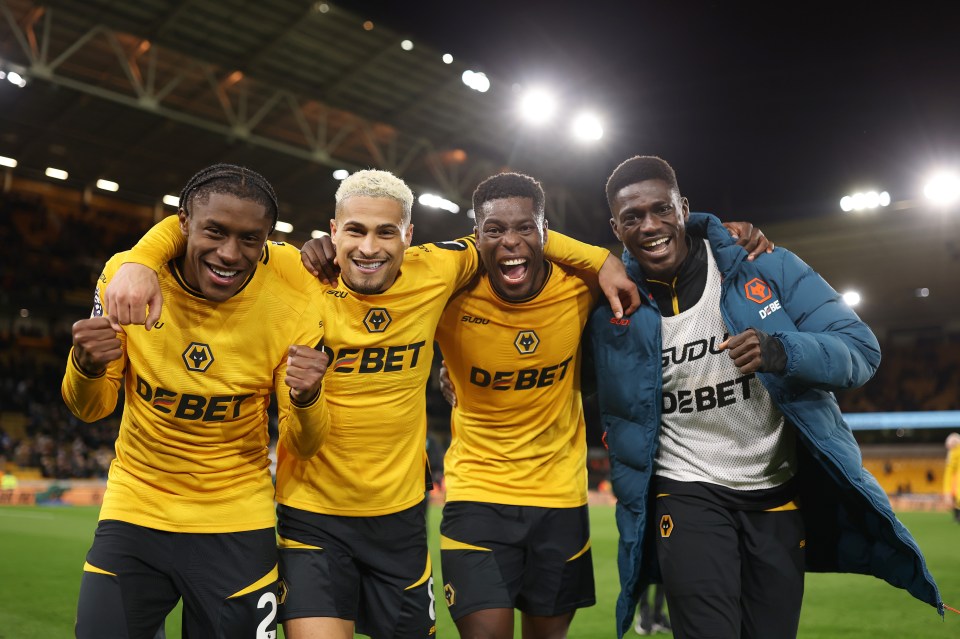 Four Wolverhampton Wanderers players celebrating a victory.