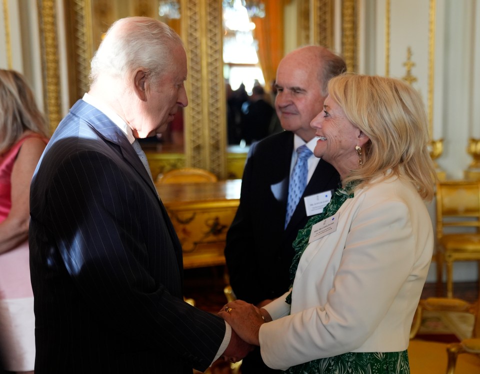 King Charles III speaking with Alistair and Heather James at a Buckingham Palace reception.