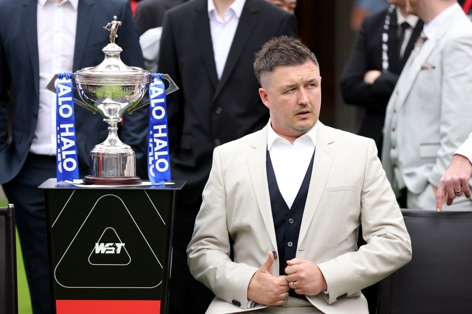 Kyren Wilson of England next to the Halo World Snooker Championship trophy.