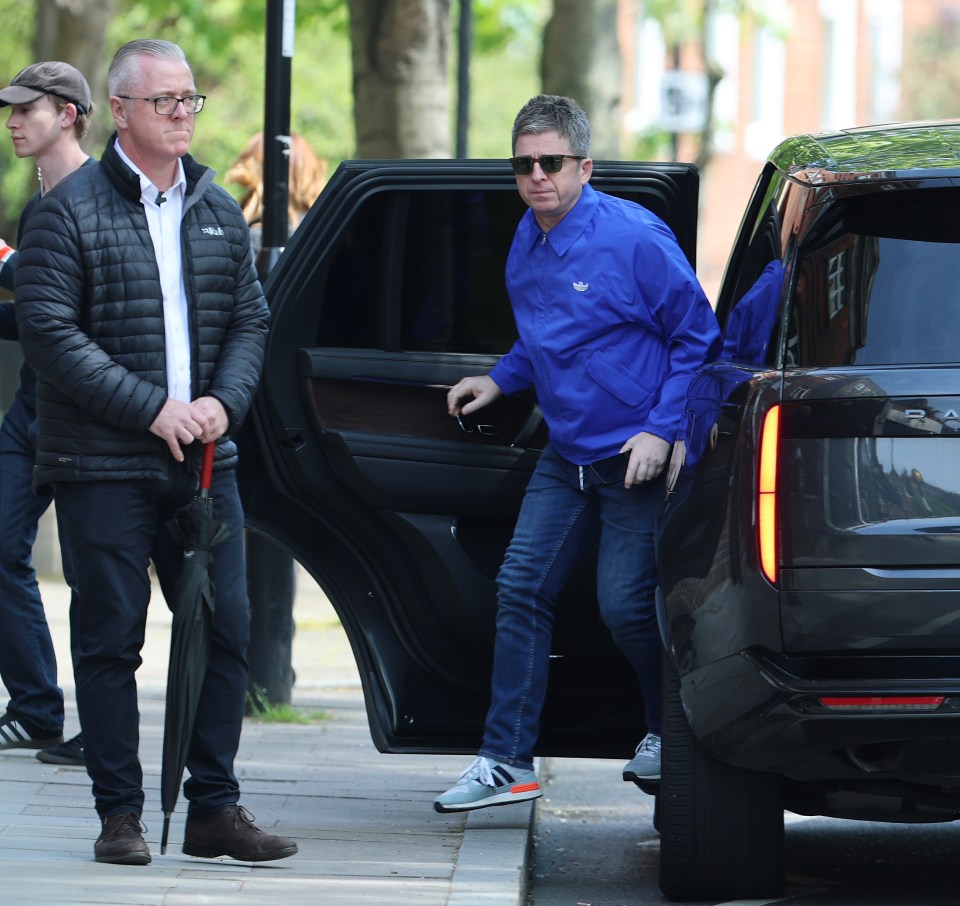 Liam Gallagher exiting a car.