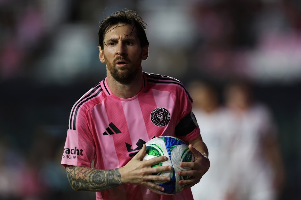 Lionel Messi holding a soccer ball.