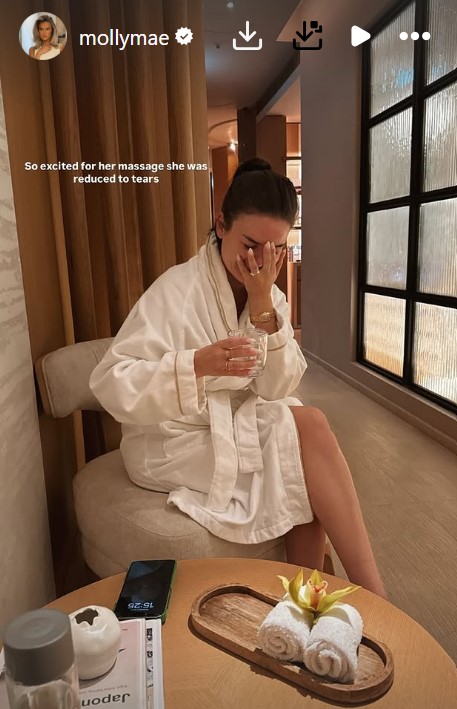 Woman in bathrobe crying tears of joy after a massage.