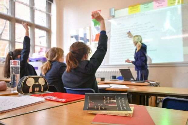 An image collage containing 1 images, Image 1 shows Students with hands raised in a classroom