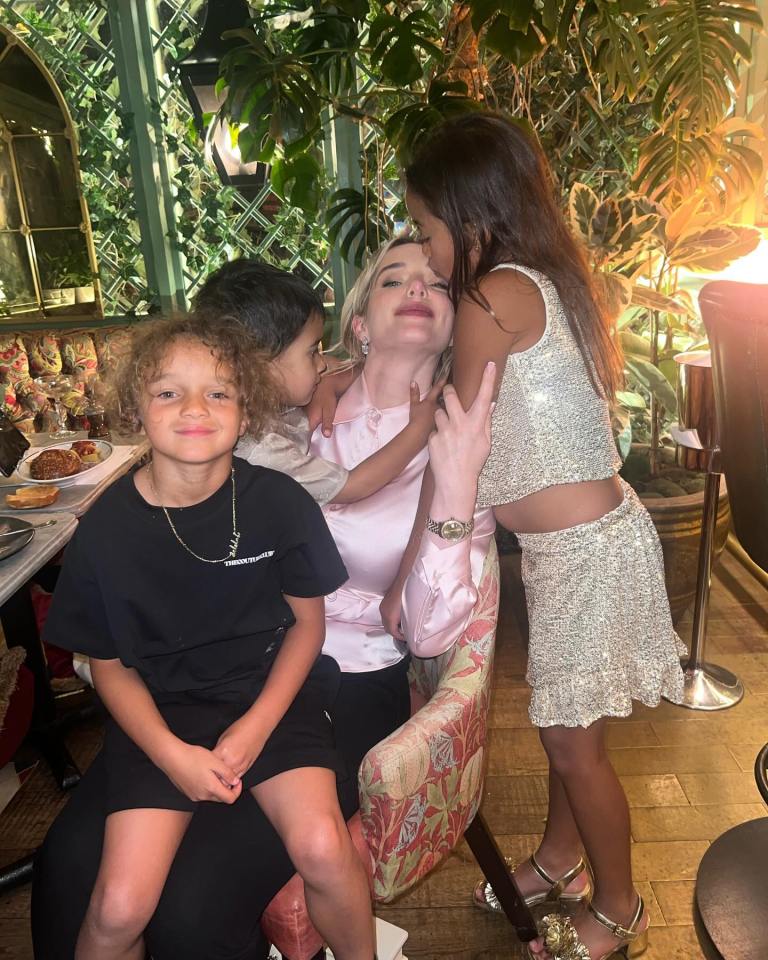 Woman with three children at a restaurant.