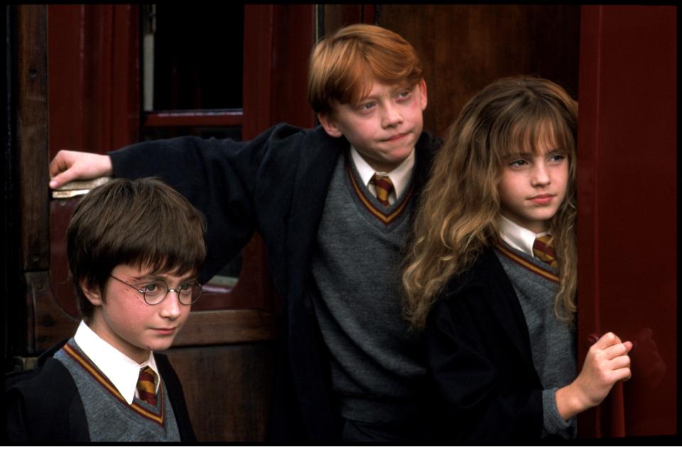 Harry Potter, Ron Weasley, and Hermione Granger in Hogwarts school uniforms.