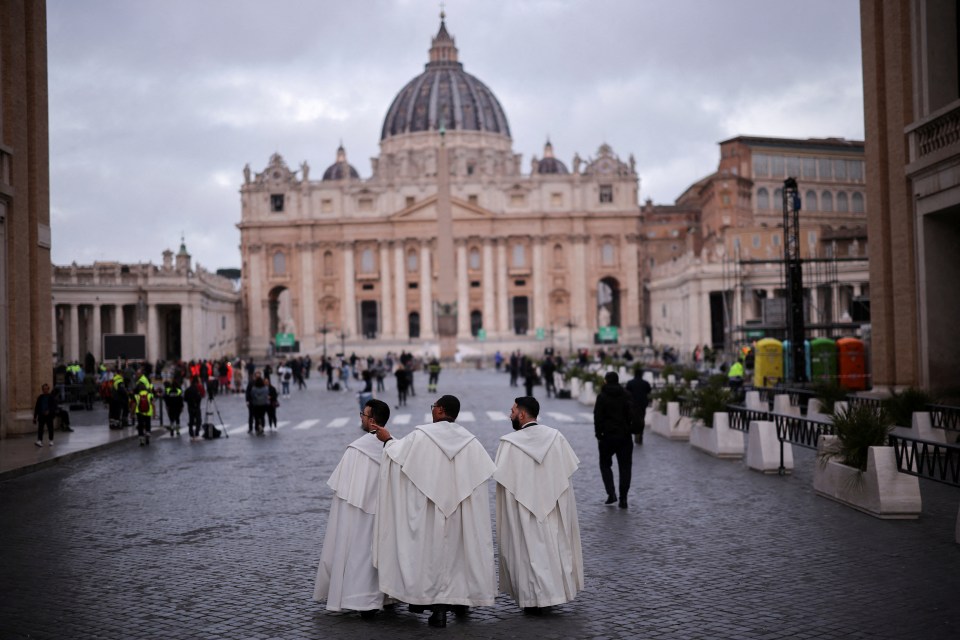 Three priests walking toward St. Peter's Basilica.