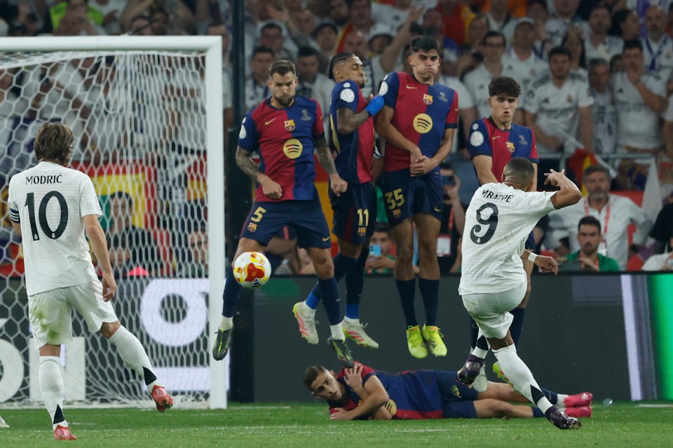 Kylian Mbappé scoring a goal during a soccer match.