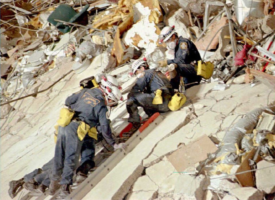 Rescue crew searching for bodies in rubble.