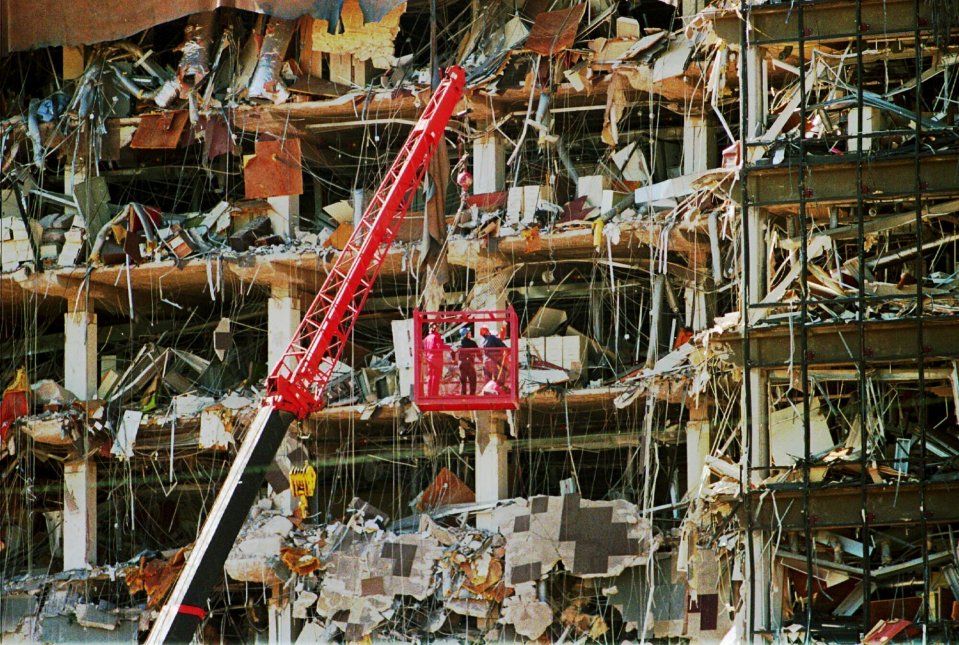 Rescue workers in a lift surveying the rubble of a destroyed building.