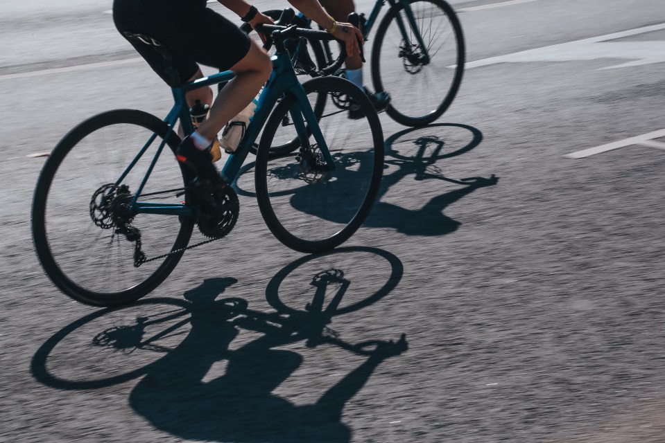 Two cyclists riding bicycles on a city street.