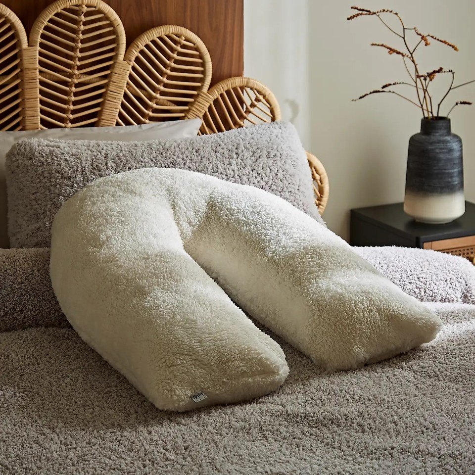 Teddy V-shape cushion on a bed.