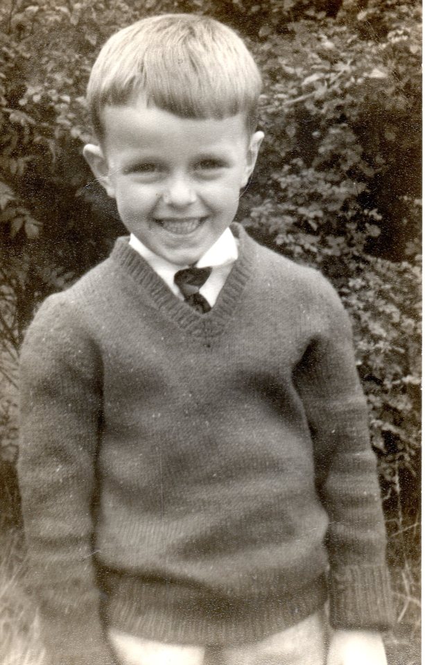 Black and white photo of a young boy smiling.