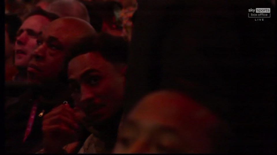 Close-up of audience members at a boxing match.