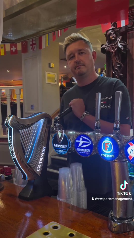 Man pouring Guinness at a bar.