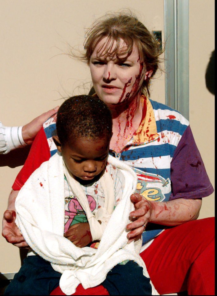 A woman holds an injured child after a bombing.