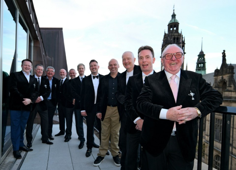 Group of men in black tuxedos at an awards dinner.