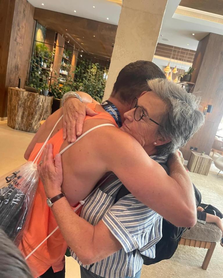 A woman embracing a person after a marathon.