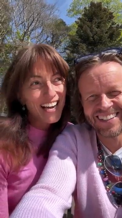 A smiling couple in pink sweaters.