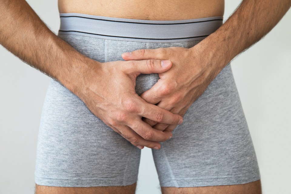 Man holding his groin in pain.