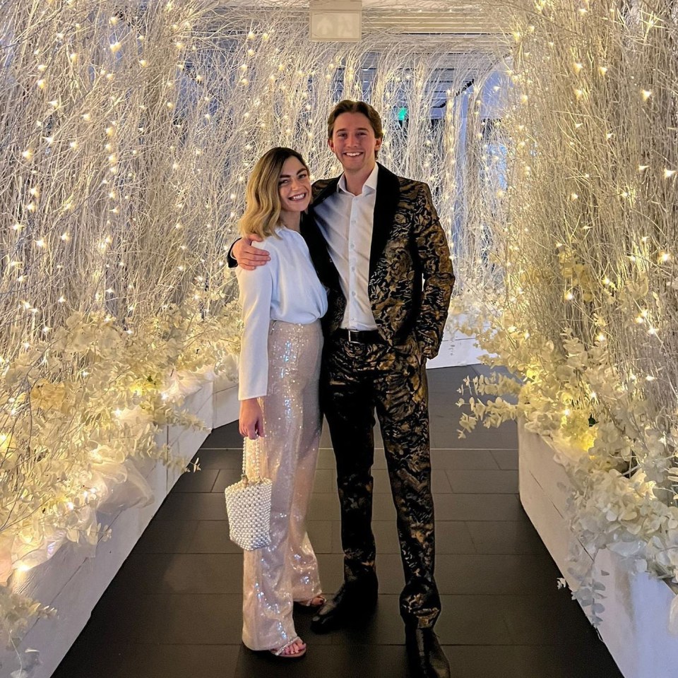 Couple posing together in a festively decorated hallway.