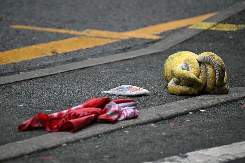 A discarded octopus toy and Liverpool flag on the ground after a car hit a crowd.