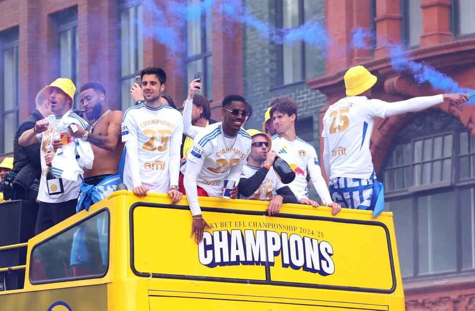 Leeds United players celebrating on a victory parade bus.